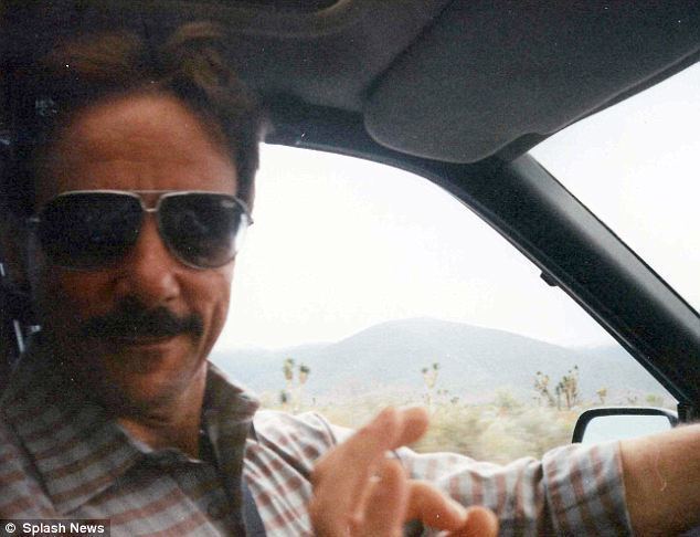 Ronald Dickson Woodroof with a mustache, wearing sunglasses and a checkered shirt while driving a car.