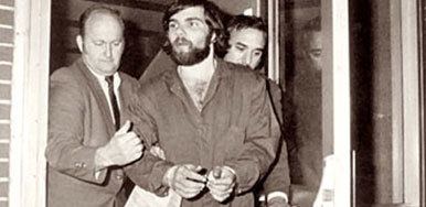 Ronald DeFeo Jr. wearing long sleeves and handcuffs on his wrist after being charged with the murders