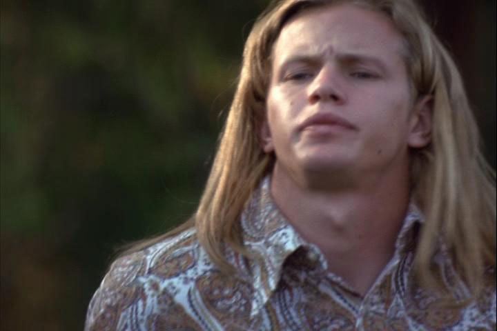 Ronnie Bass wearing a white and brown polo in a movie scene from the 2000 film Remember the Titans