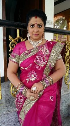 Roopa Sree wearing a pink dress, a necklace, earrings, and bracelets