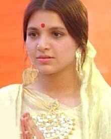 Roshini (actress) wearing a yellow Indian dress and a bindi on her head