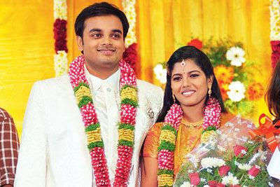 Roshini smiling with Jack during their wedding day and wearing traditional Indian wedding outfit.