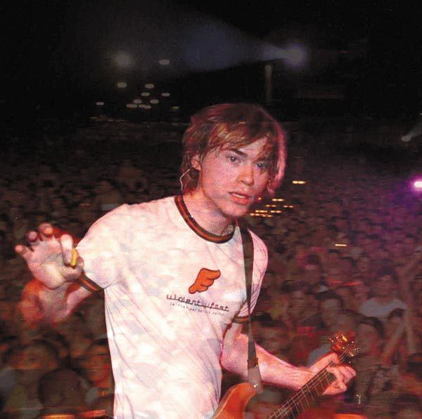 Ross Childress playing the guitar while wearing a white printed shirt