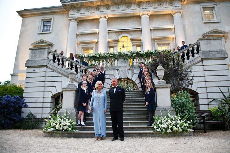 Camilla smiling with Prince Charles while standing in front of the Royal Lodge's stairs together with the boys and girls behind them