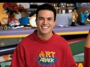 Rui Torres smiles while hosting on "Art Attack" wearing a red jacket