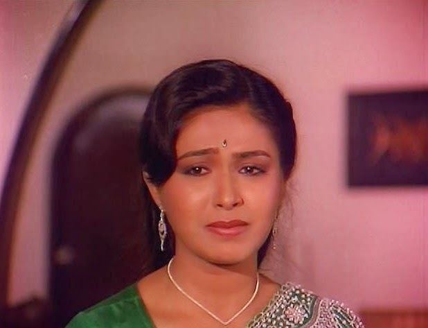 Rupini's sad face while wearing a green beaded dress, necklace and earrings