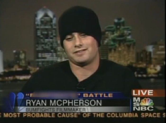 Ryen McPherson, live on a TV news, wearing a black shirt and black bonnet