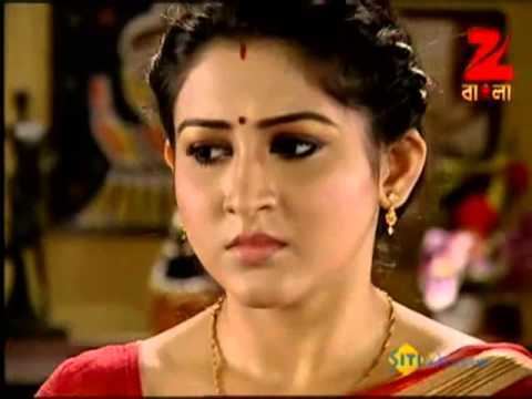 Oindrila Sen wearing red dress and gold jewelries in a scene from the 2009 movie, Saat Paake Bandha