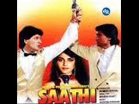 The poster of the movie SAATHI 1991, On the left Aditya Pancholi is serious, mouth half open, standing with his left hand holding a gun up with a yellow round spotlight at the back, looking to his left has black hair wearing a white long sleeve polo with black bowtie under a gold vest, in the middle Varsha Usgaonkar is serious, holding a black mic, has red hair, wearing a long earring  and red dress, at the right Mohsin Khan is serious looking to his right, holding Aditya’s hand, has black hair wearing a white polo under a cream coat, below is the title “SAATHI”