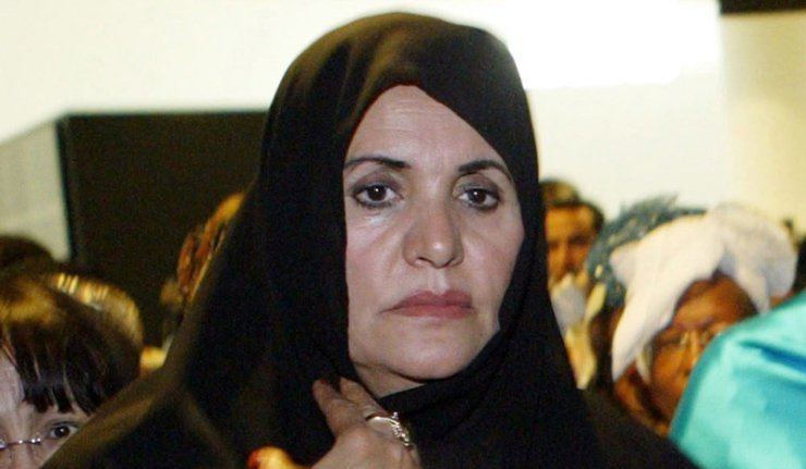 Safia Farkash in a gathering with a sad expression wearing a black hijab.