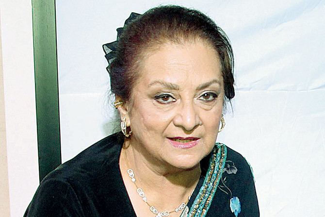 Saira Banu wearing black and blue dress, earrings and necklace