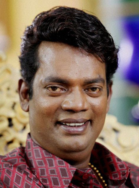 Salim Kumar wearing red and brown long sleeves while smiling