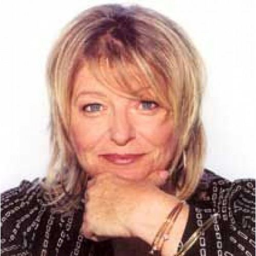 Sally Boazman smiling while wearing a black and white long sleeves and bracelet