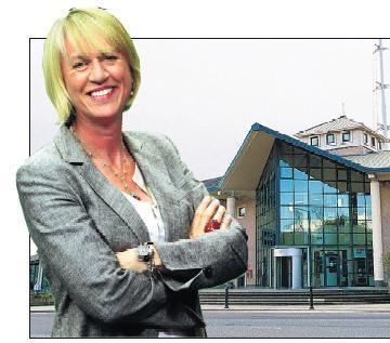 Standing Sally Taylor with a building on the right side