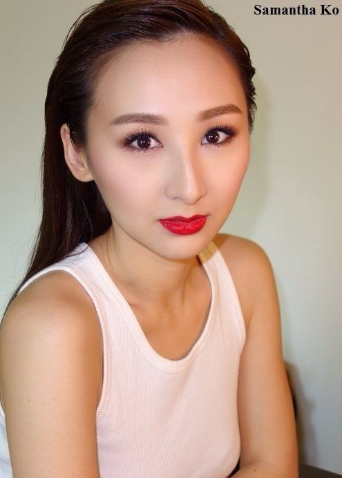 Samantha Ko wearing a red lipstick and white top