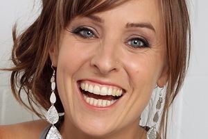 Samantha Lane smiling while wearing a dangling earrings