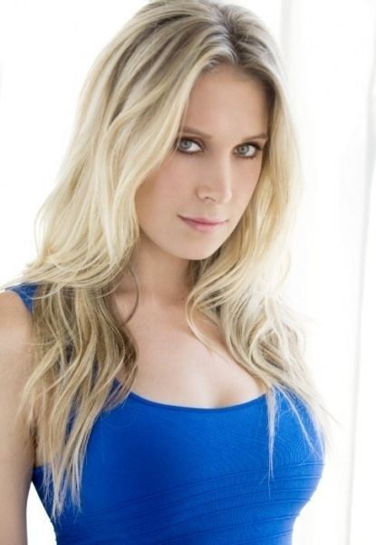 Samantha Schacher with blonde hair while wearing blue top