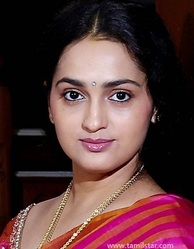 Sangita Madhavan wearing a pink and orange dress and gold necklace