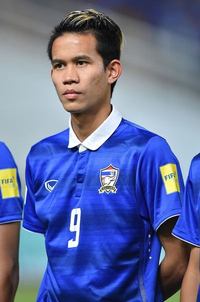 Sanrawat Dechmitr seriously looking, has black hair with blonde highlights wearing a blue jersey with #9 at the center and a logo on both sides on it
