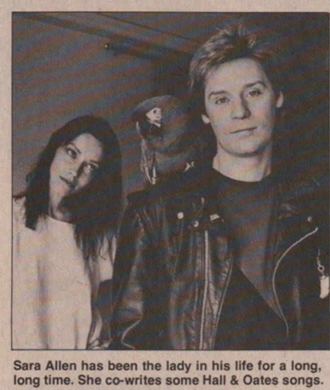 Sara Allen looking at parrot and Daryl Hall wearing black leather jacket