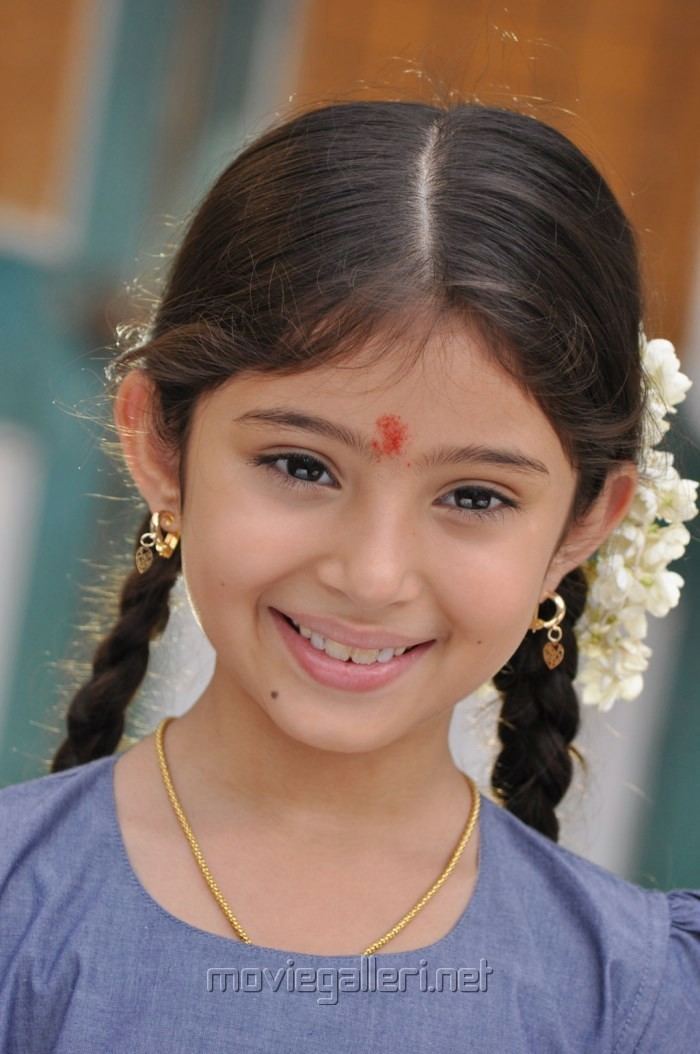 Sara Arjun smiling with her braided hair while wearing a blue blouse, necklace and earrings