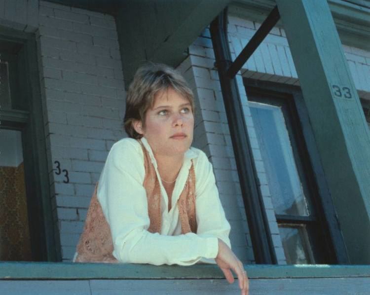 Sarah Holcomb wearing a white long sleeve paired with brown vest