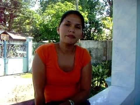 Woman wearing orange shirt while sitting on a balcony