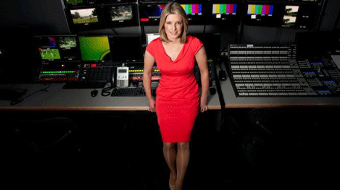 Sarah Stirk smiling while wearing a red dress