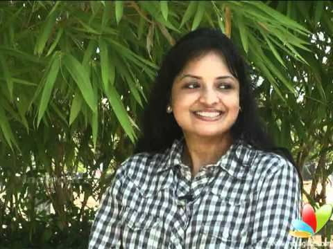 Savitha Reddy smiles while wearing a black and white shirt