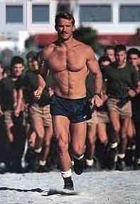 Scott Helvenston running without a shirt with several men behind him