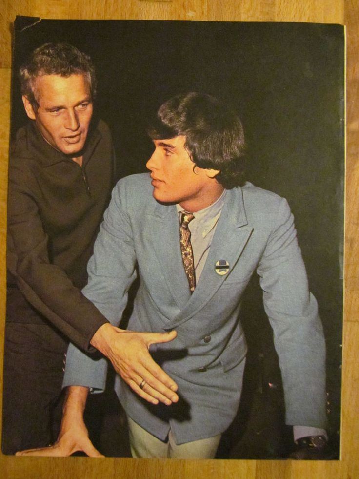Paul Newman talking to his son Scott Newman while he is wearing black long sleeves and Scott wearing a blue coat, long sleeves, and brown necktie