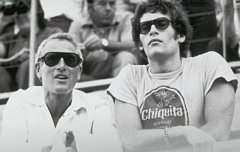 Paul Newman and his son Scott Newman watching the Ontarion 500 automobile race in Ontario, California while wearing sunglasses