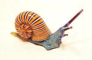 A colorful glass art of a Sea Snail with a striped yellow shell.