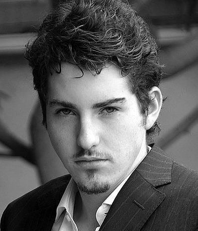 Sean Flynn (actor) wearing a white shirt and a black suit