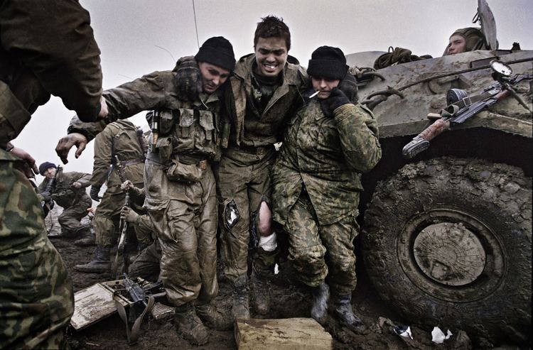 Russian marines help a wounded fellow soldier after being caught in an ambush near Tsentaroy, Chechnya during the Second Chechen War