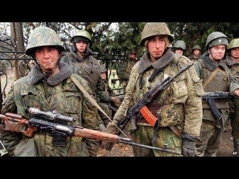 Group of soldiers holding their guns during the Second Chechen War while wearing their army uniform with helmets, tactical vest, and gloves