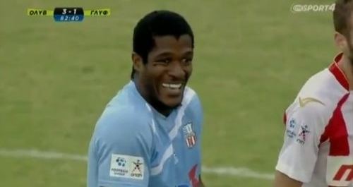 Serge Djiehoua laughing while on a football game and wearing blue jersey