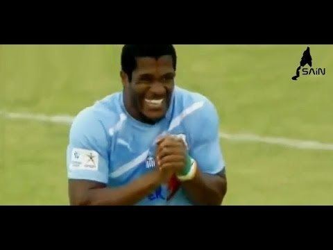Serge Djiehoua laughing while on a football game and wearing blue jersey