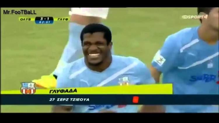 Serge Djiehoua laughing while on a football game and wearing blue jersey