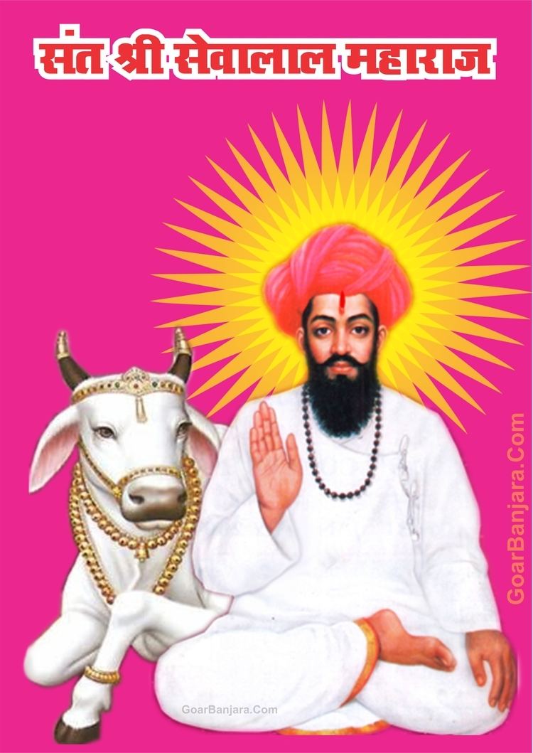 Poster of Sevalal with a mustache and beard, wearing a brown necklace, red turban, and a white robe with a white cow on his side adorned with gold accessories.
