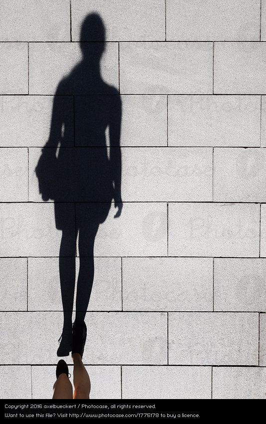 Shadow of a Woman shadow of a woman walking on pedestrian street a Royalty Free