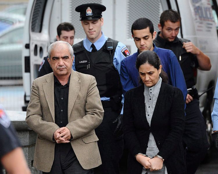 Mohammad Shafia (left), his wife Tooba Yahya, and their son, Hamed, are escorted by police officers into the court on the first day of their trial in Kingston, Ontario