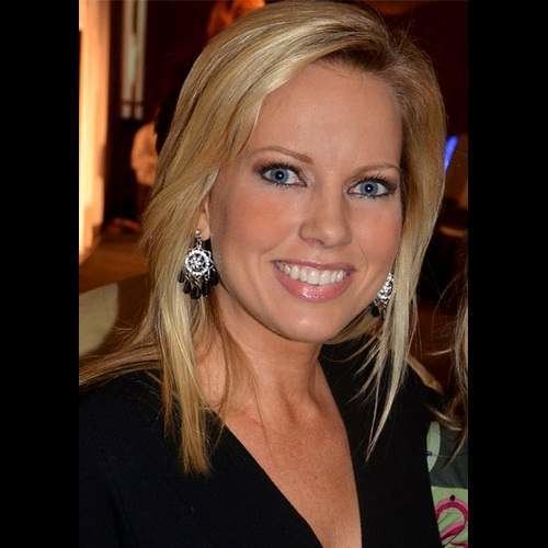 Shannon Bream smiling with blonde straight hair while wearing earrings and a black blouse with a low-cut neckline