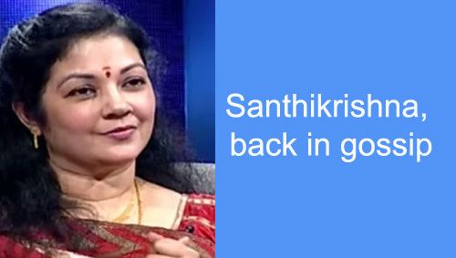 Shanthi Krishna (left) smiling with her black hair, a nose piercing, and a bindi on her forehead wearing dangled earrings, a gold necklace, and a saree. A quote on her right state “ShanthiKrishna back in gossip”