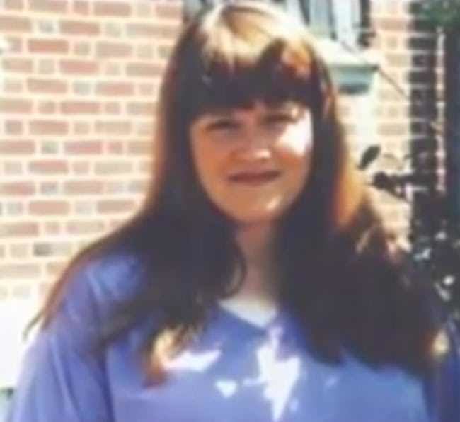 Sharon Lopatka with long hair and bangs and wearing a blue shirt.