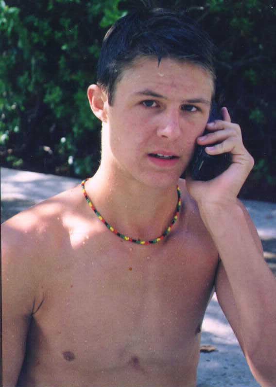 Shawn Toovey holding a telephone and wearing necklace