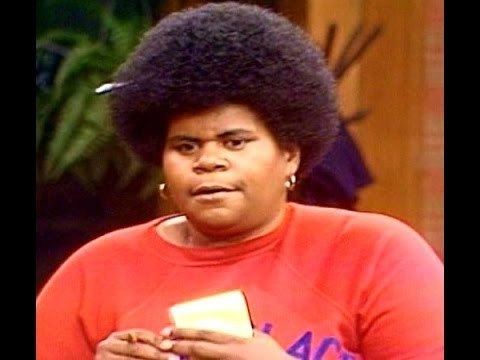 Shirley Hemphill wearing earrings and an orange shirt.