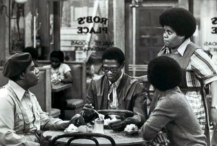 Scene from "What's Happening", a 1977 TV Series starring Fred Berry, Ernest Lee Thomas, Haywood Nelson, and Shirley Hemphill standing in front of them.