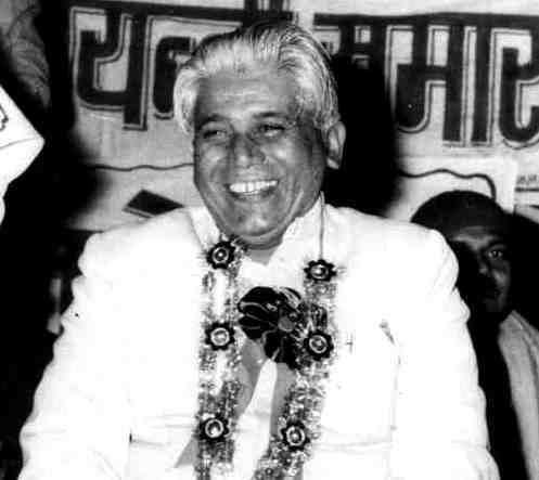 Shivmangal Singh Suman wearing white long sleeves and rosette lei while laughing