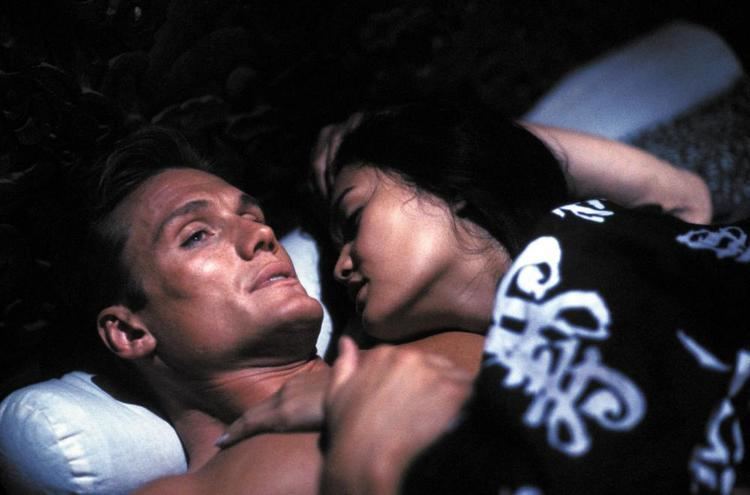 Tia Carrere and Dolph Lundgren lying on the bed in a movie scene from the 1991 film Showdown in Little Tokyo